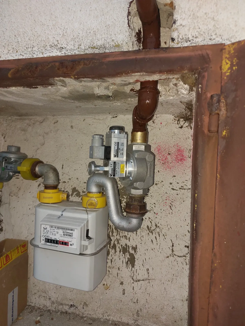Instalacje gazowe – gazowy licznik z reduktorem ciśnienia i metalowymi przyłączami zamontowany w ścianie