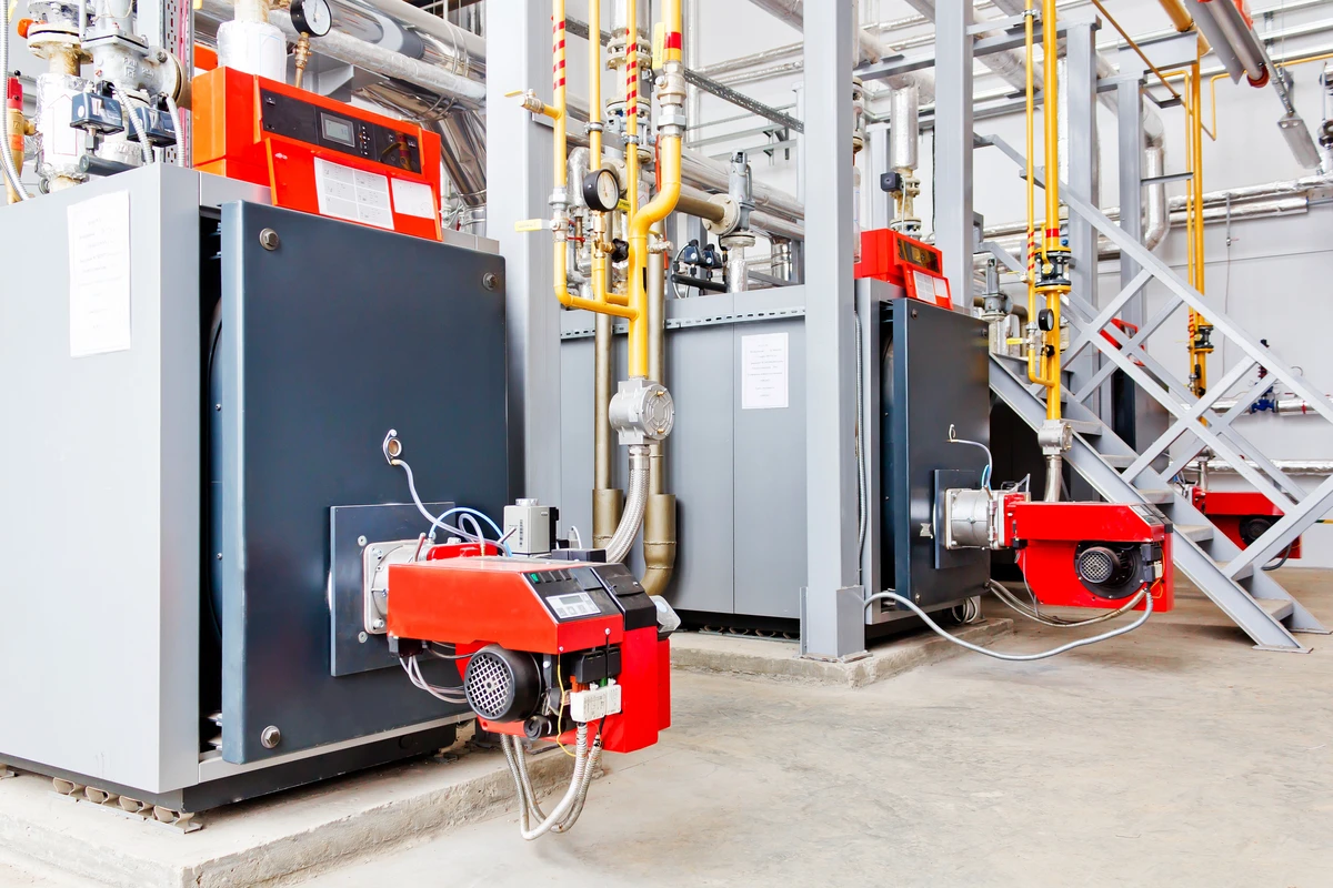 Kotły gazowe z automatycznymi palnikami w pomieszczeniu kotłowni, element instalacji CO